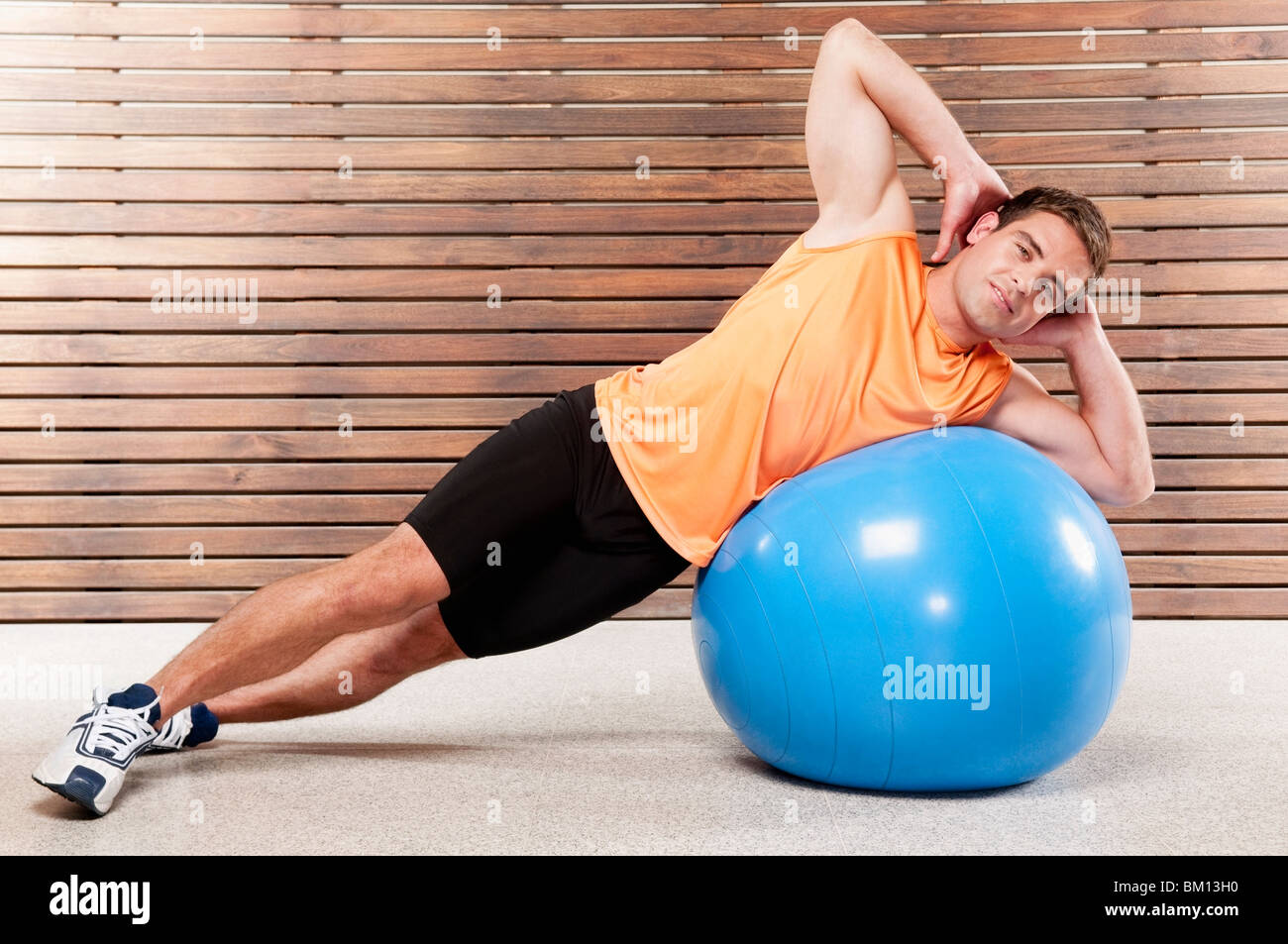 Mann auf einer Fitness-Ball in ein Fitness-Studio trainieren Stockfoto