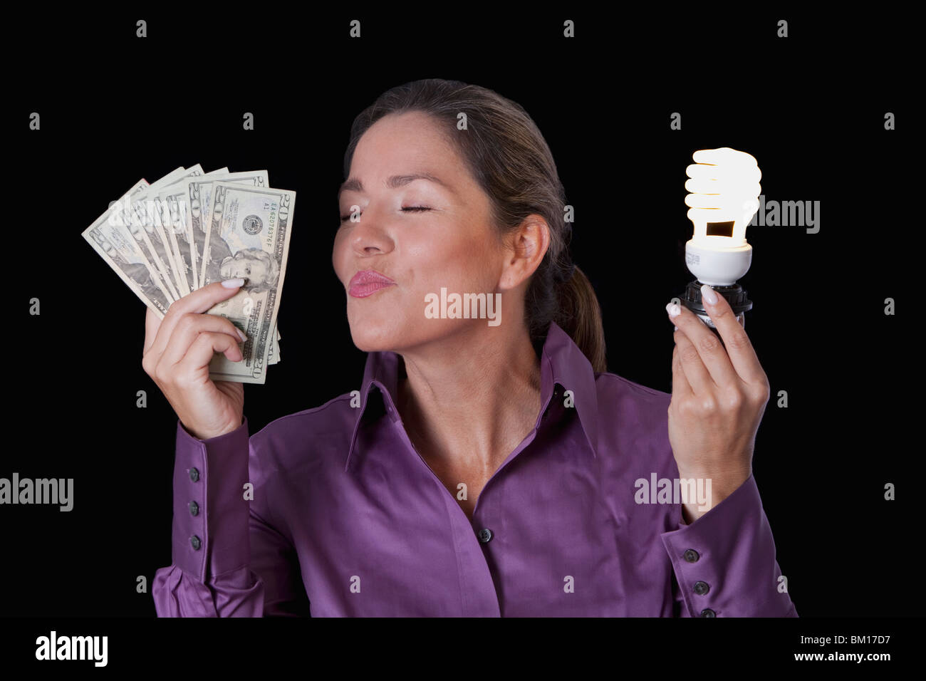 Frau mit Banknoten und eine kompakte Leuchtstoff Glühlampe Stockfoto