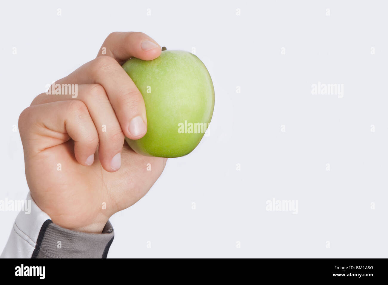 Person, die Hand, die einen grünen Apfel Stockfoto