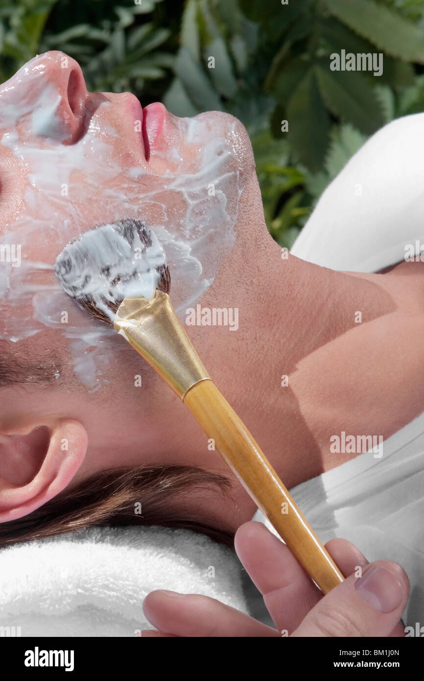 Kosmetikerin auftragen Gesichtsmaske auf das Gesicht des Mannes Stockfoto