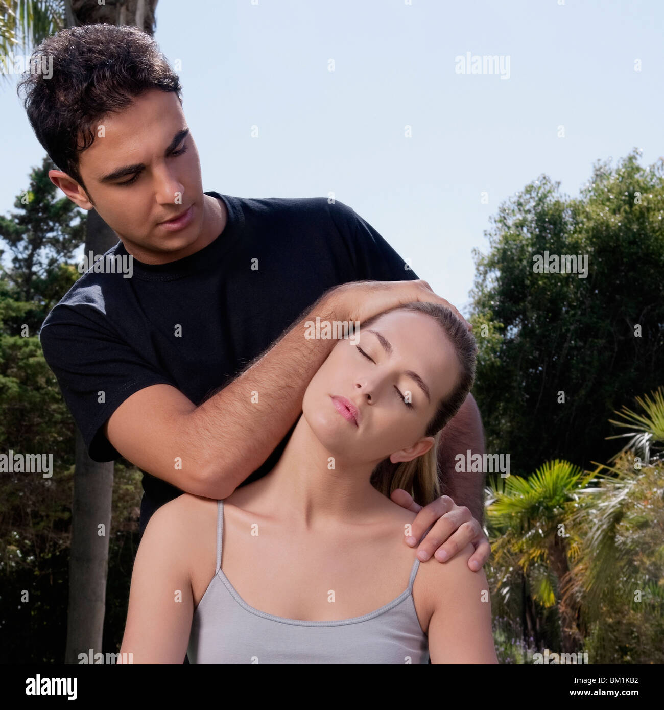 Mann, eine Frau während der Yoga-Praxis zu unterstützen Stockfoto