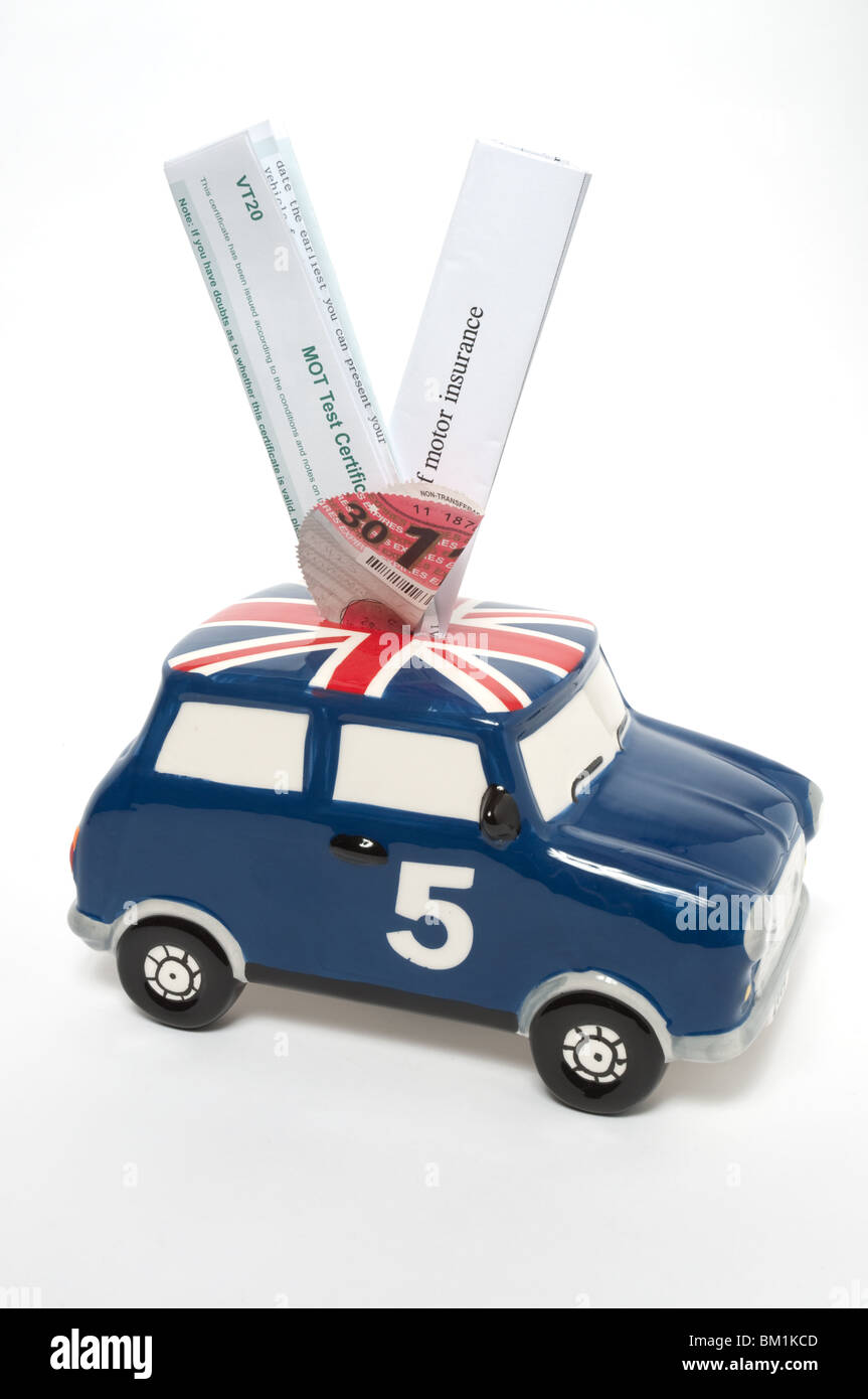 Kosten für den Betrieb eines Autos. Piggy Bank in Form eines Mini mit MOT, Vignette und Versicherungsunterlagen. Stockfoto