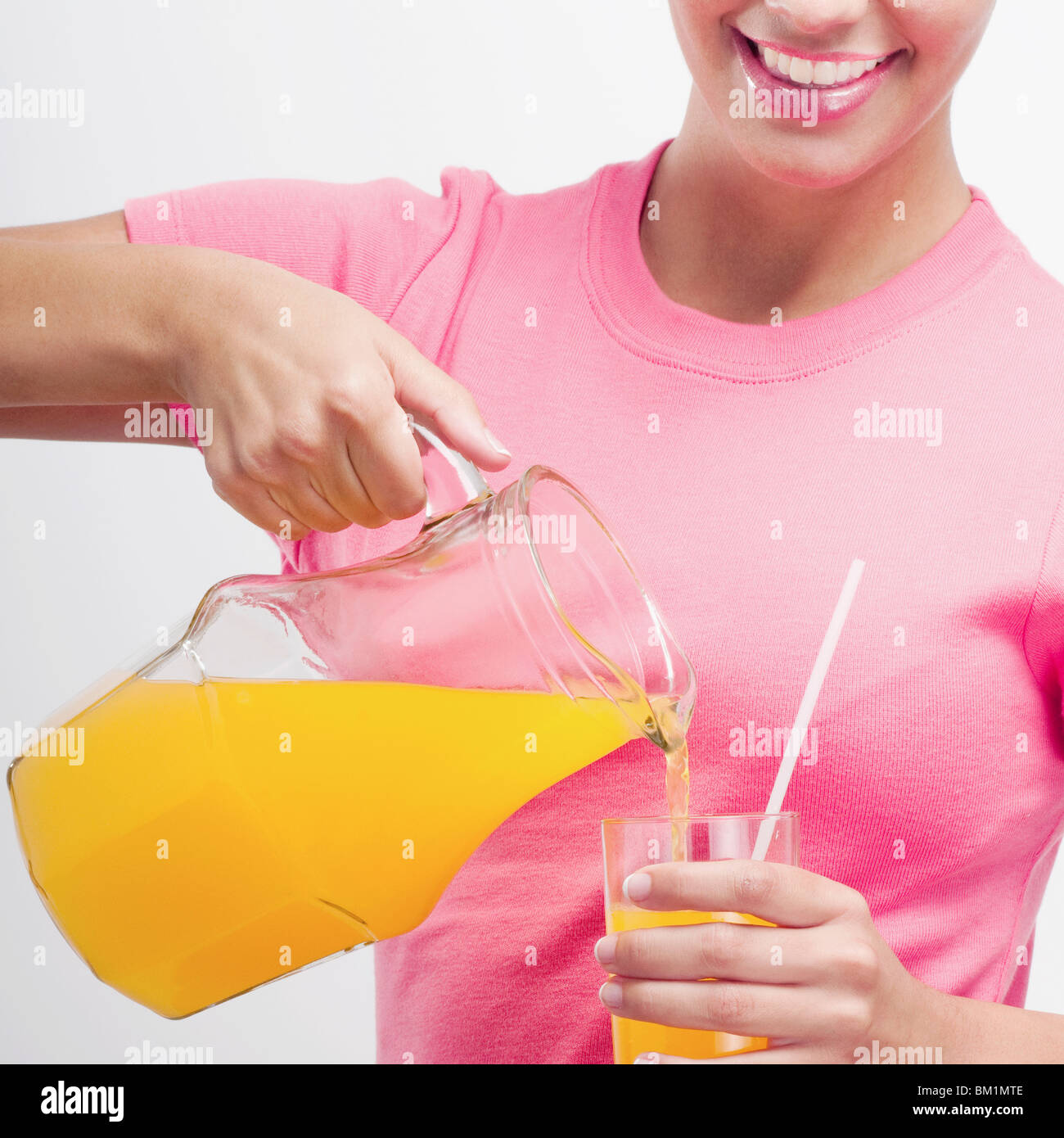 Orangensaft mit einer Kanne gießen Frau Stockfoto