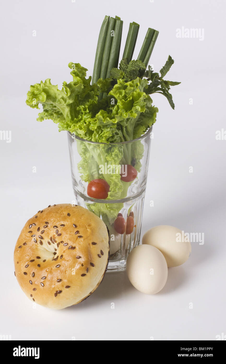 Glas voll mit Gemüse mit einem Bagel und braunen Eiern Stockfoto