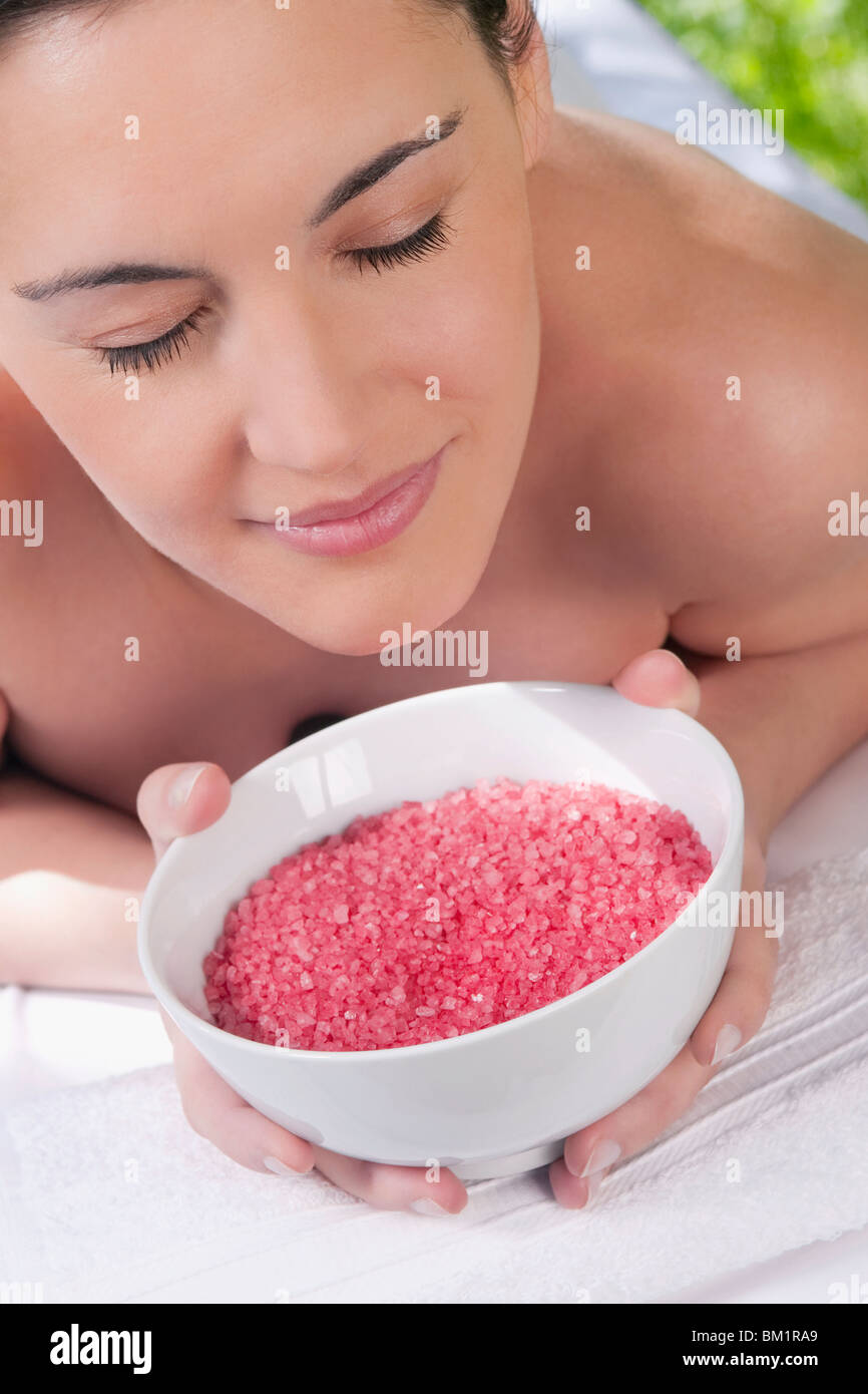 Nahaufnahme einer Frau liegend auf einem Massagetisch und riechen eine Schüssel mit Badesalz Stockfoto