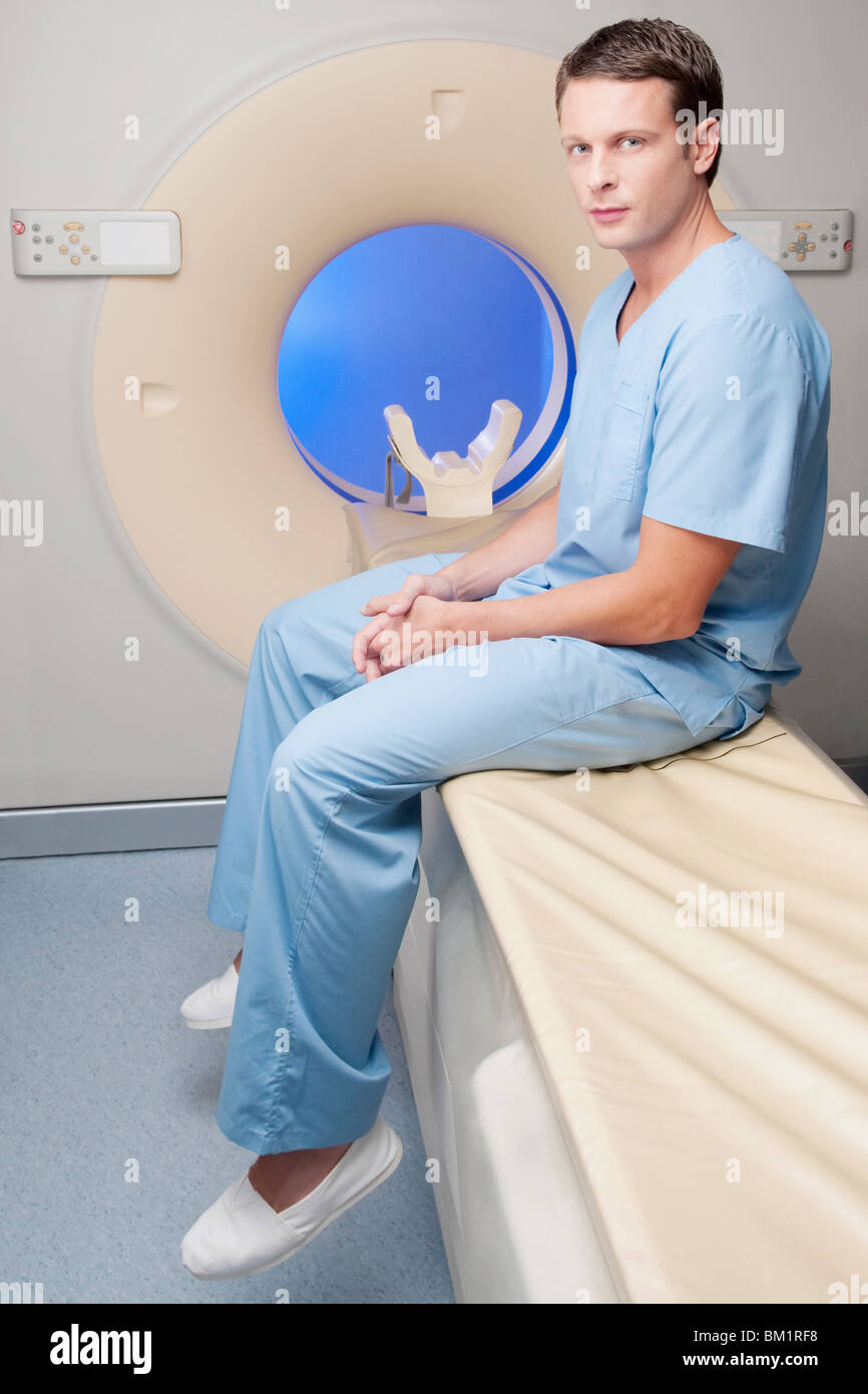 Porträt von ein Healthcare Arbeiter sitzt auf einem CAT-Scan-Maschine Stockfoto