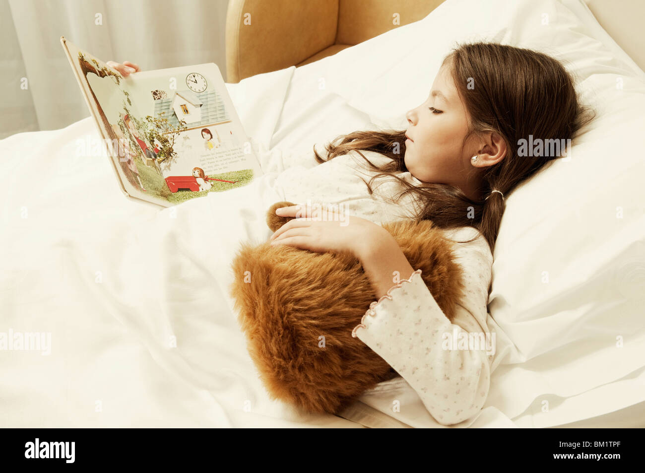 Mädchen, ein Comic-Buch in einem Krankenhausbett Stockfoto