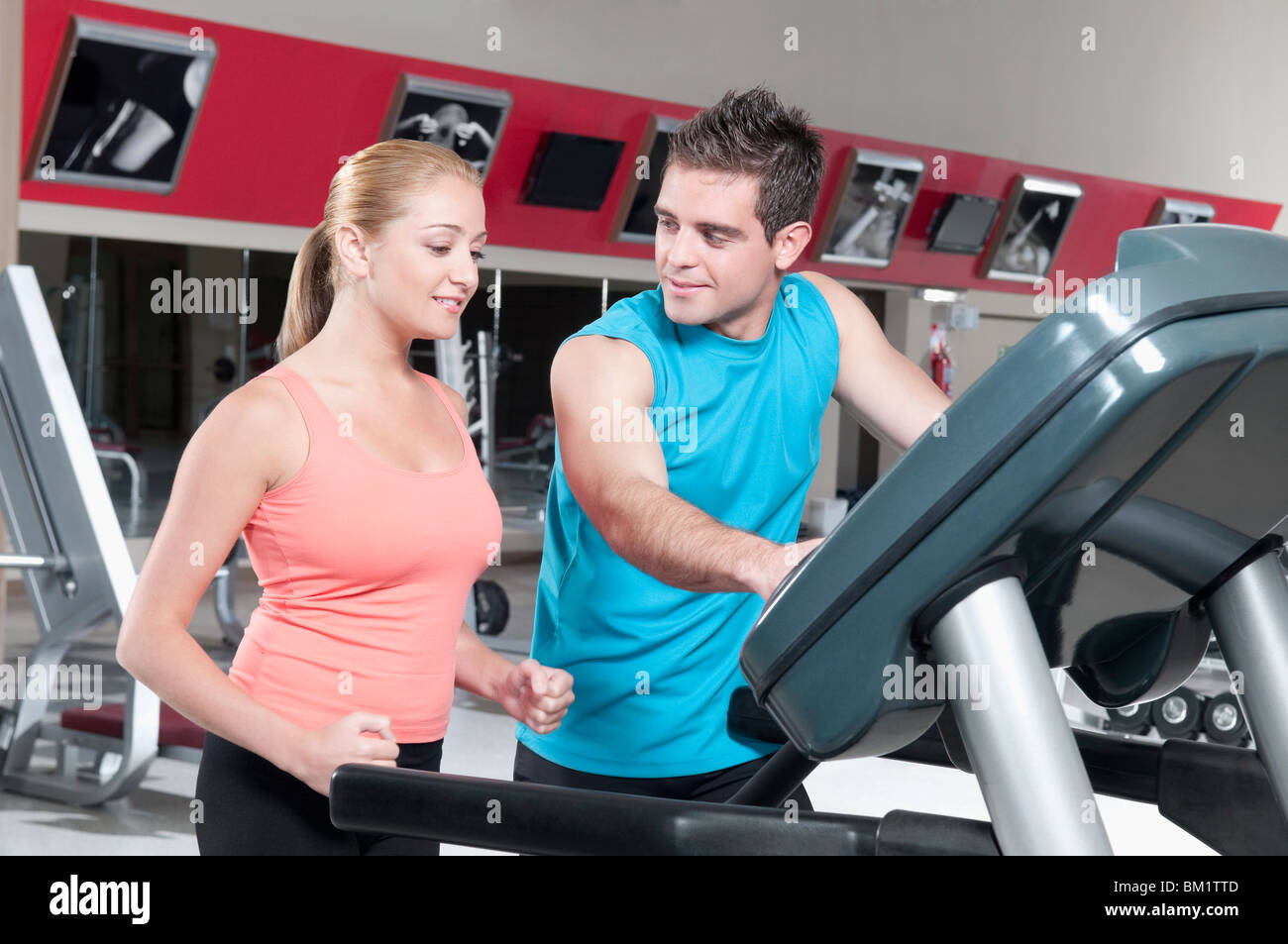 Mann eine Frau auf einem Laufband zu unterstützen Stockfoto