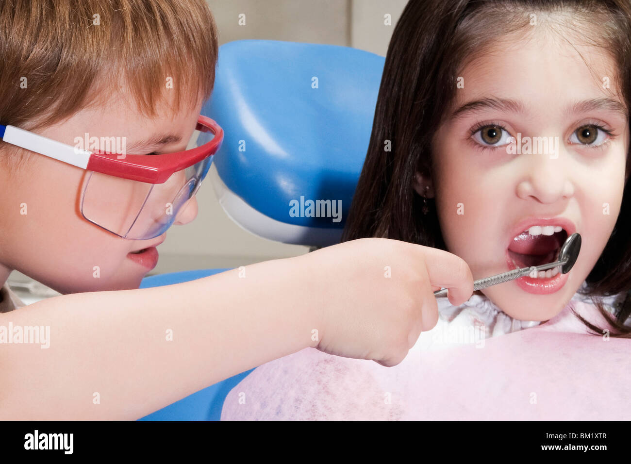 Junge als Zahnarzt zu imitieren und Prüfung eines Mädchens Zähne Stockfoto
