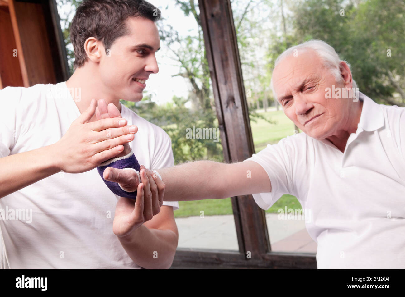 Physiotherapeut untersucht die Hand eines Mannes Stockfoto