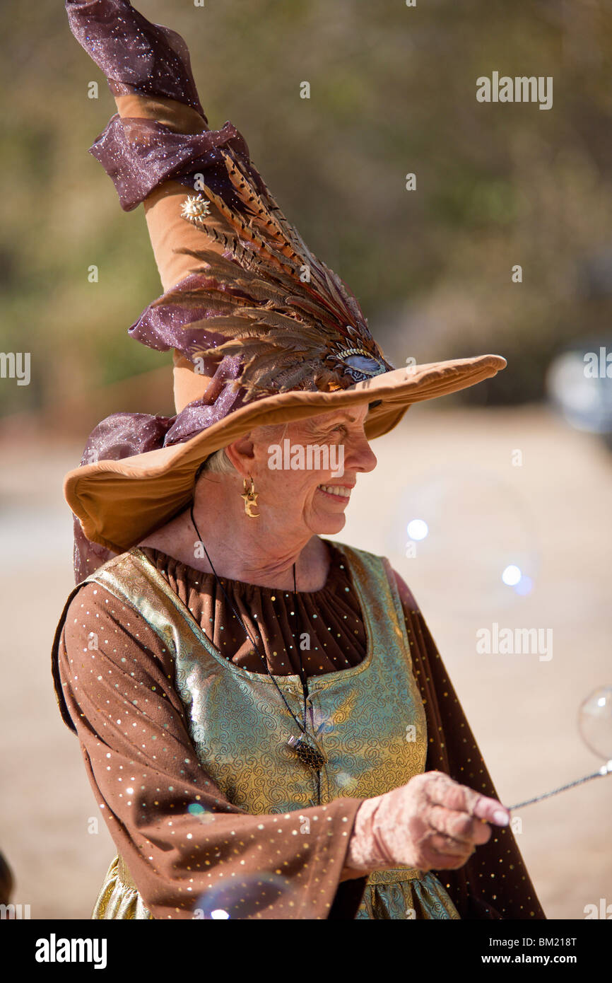 Gainesville, FL - Jan 2009 - Senior Woman in zeitgenössischer Kleidung gekleidet wie eine Hexe Kinder mit Seifenblasen unterhält Stockfoto