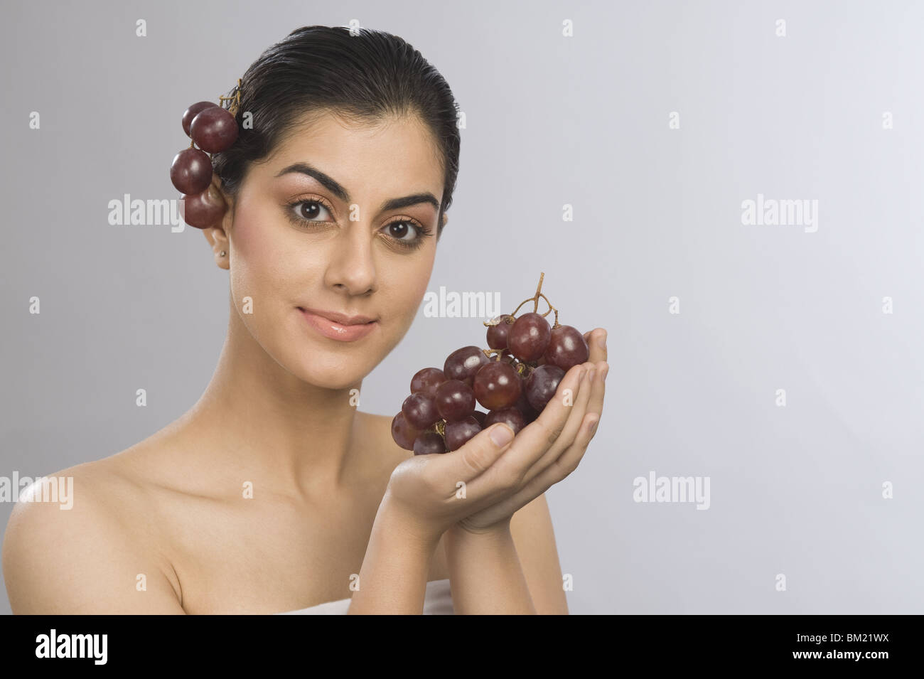 Porträt einer Frau mit roten Weintraube Stockfoto