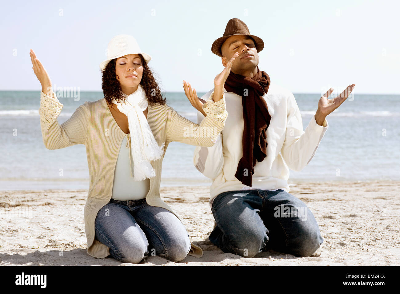 Paar am Strand meditieren Stockfoto
