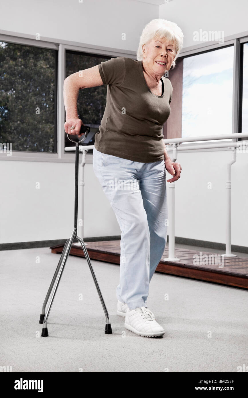 Behinderte Frau zu Fuß mit einem Stock Stockfoto