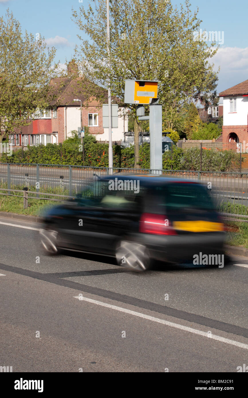 Ein schwarzes Auto, Beschleunigung vorbei einen Gatso Blitzer auf der A316 große Chertsey Road, Hounslow, UK. SIEHE BESCHREIBUNG Stockfoto