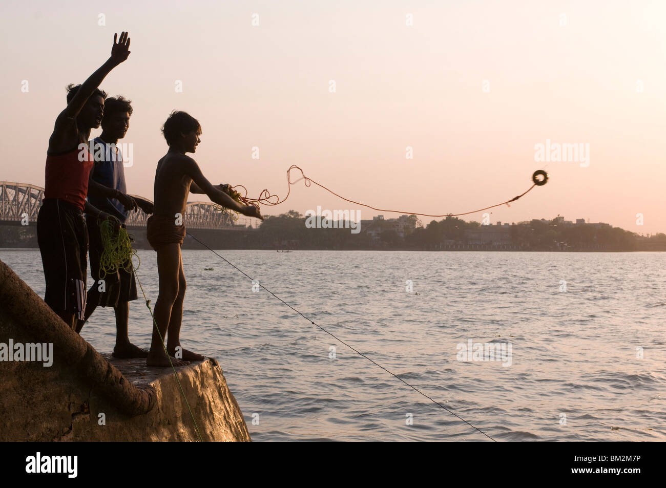 Jungen Fischen für Metall-Münzen in Howrah Fluss, Kolkata (Kalkutta), Westbengalen, Indien Stockfoto