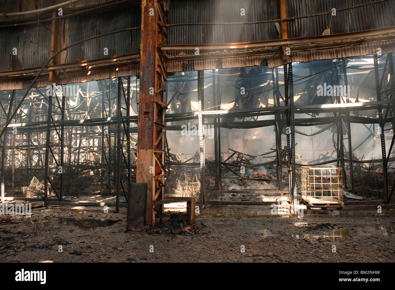 Schwere Fabrik Lager Feuer Stahl Träger verdreht und geschmolzen Stockfoto