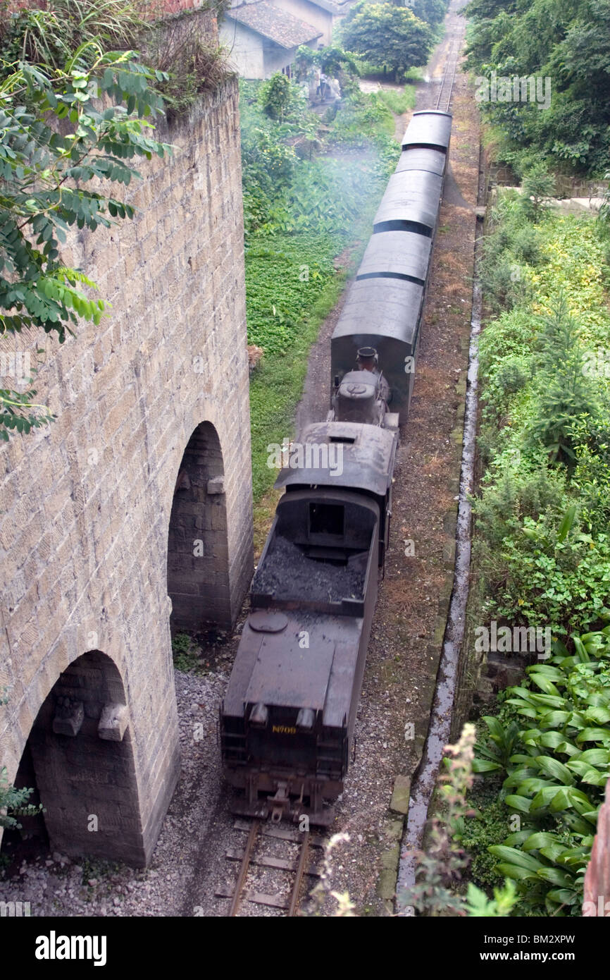 Die Jiayang Dampfzug fährt vorbei an einer alten aufgelösten Kohle-Silo in Kohle historischen Bergbaugebiet in Sichuan in China. Stockfoto