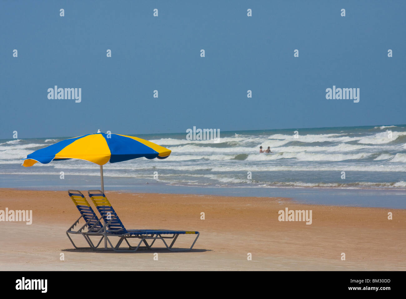 Ein schönes Bild von Daytona Beach mit einem Sonnenschirm und Stühlen. Nette Anzeige Raum in diesem Bild. Blaue und gelbe Sonnenschirm und Stuhl Stockfoto