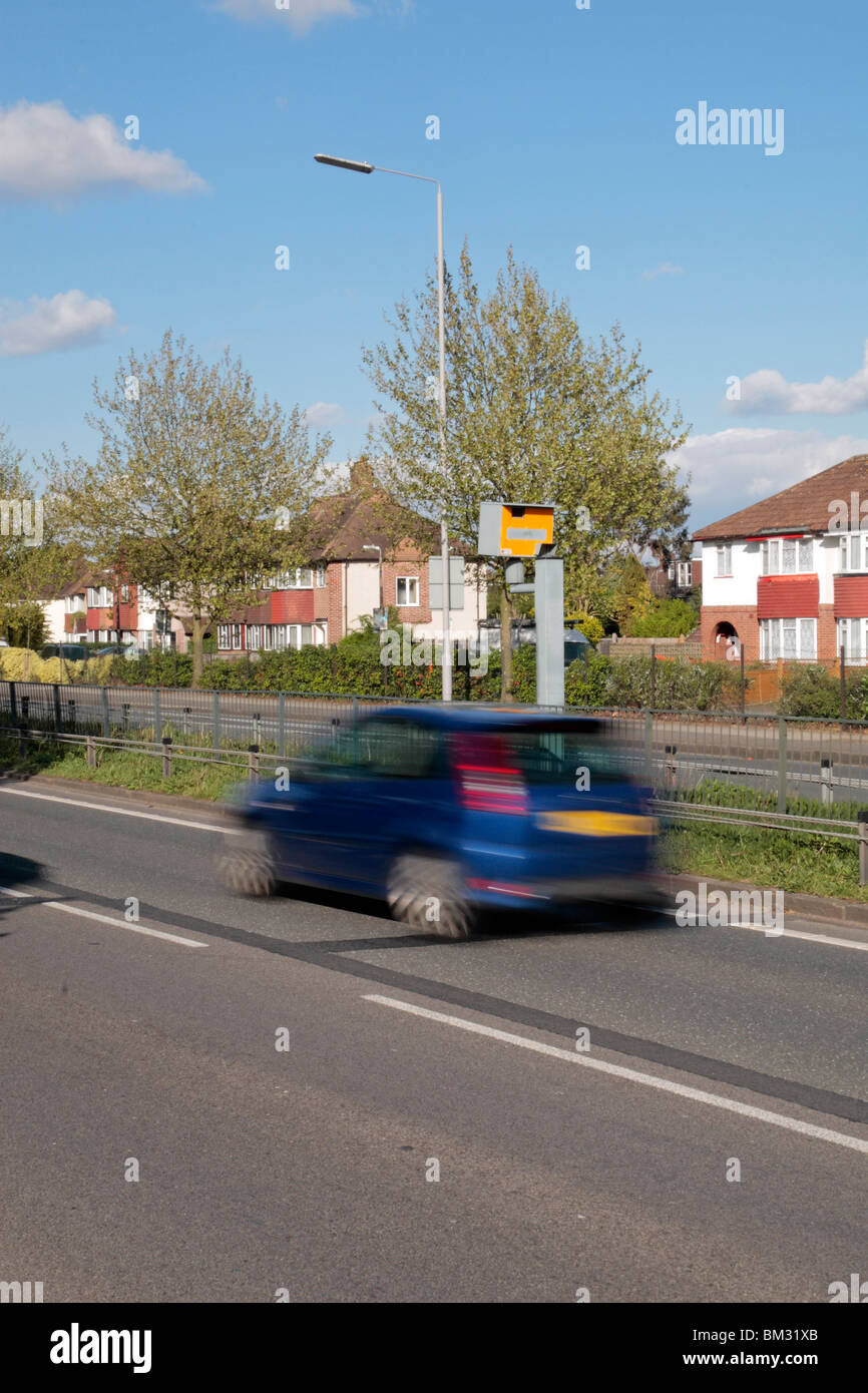 Ein blaues Auto, Beschleunigung vorbei einen Gatso Blitzer auf der A316 große Chertsey Road, Hounslow, UK. SIEHE BESCHREIBUNG Stockfoto