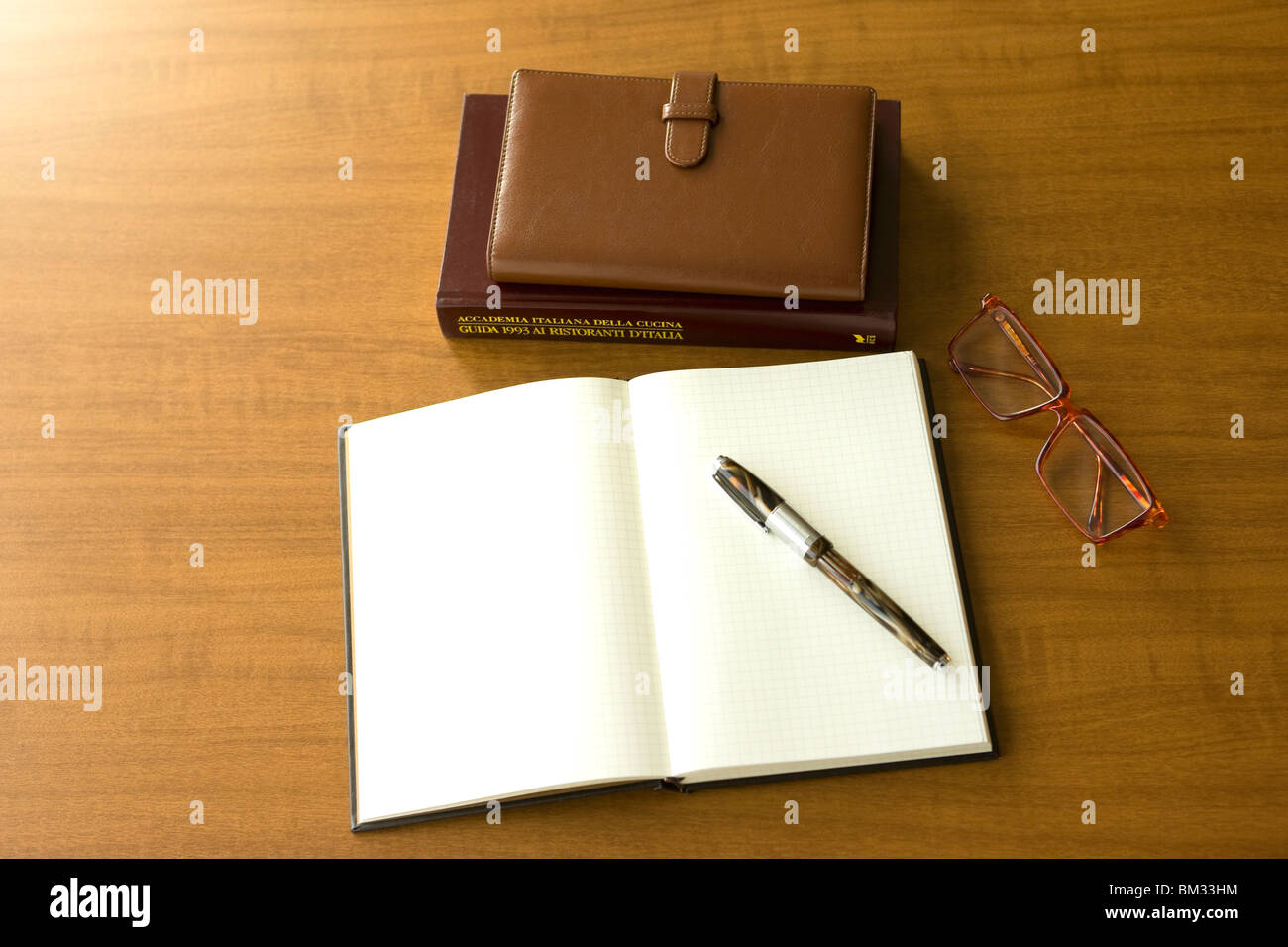 Tagebuch, Kugelschreiber, Notizblock und Gläser auf einem Schreibtisch Stockfoto