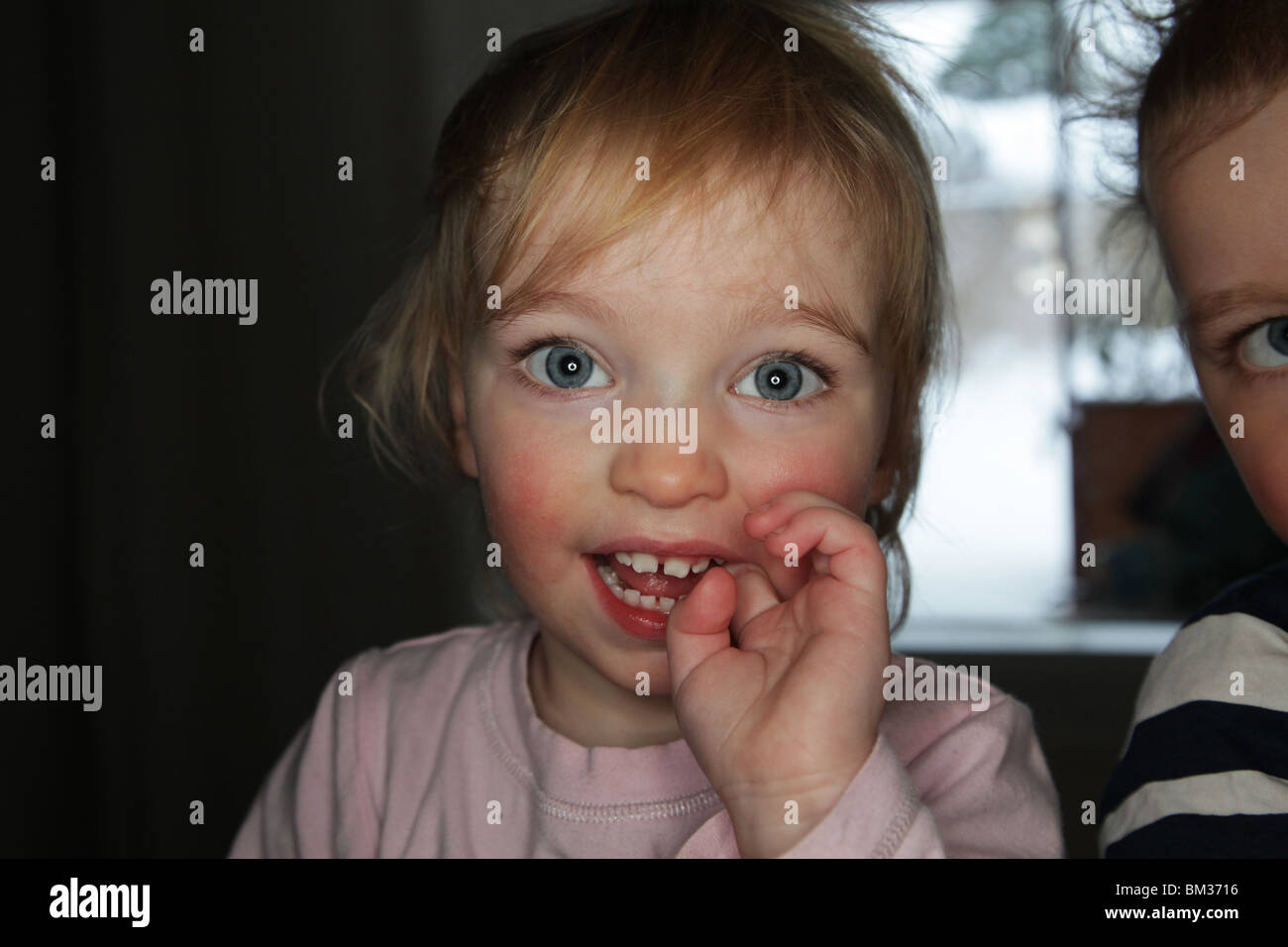 BABY GIRL MIT FINGER IM MUND: Ein Jahr altes Mädchen mit Handfinger im Mund Modell, das mit Ringblitz aufgenommen wurde Stockfoto
