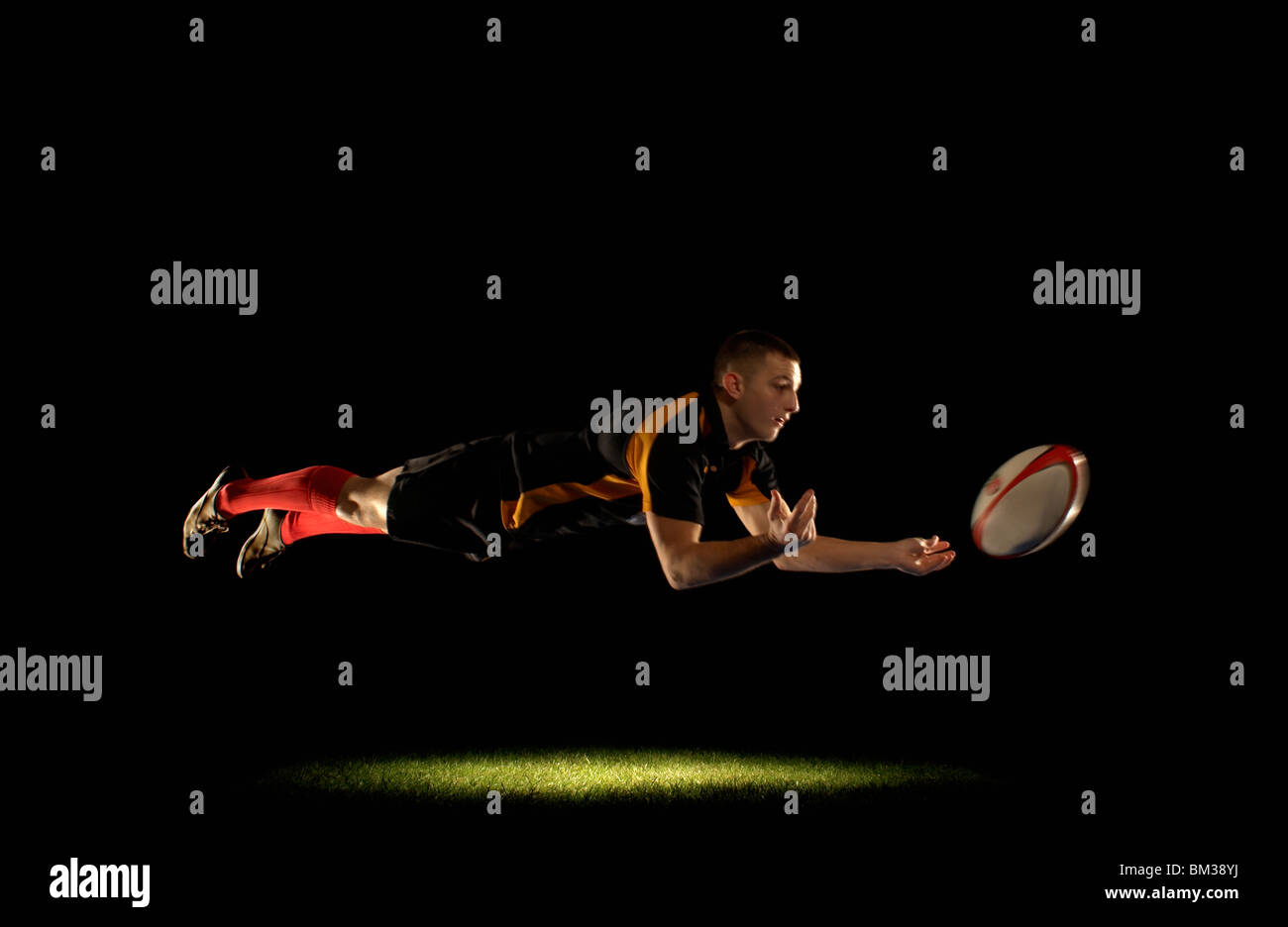 Rugby-Spieler Tauchen und Weitergabe Stockfoto