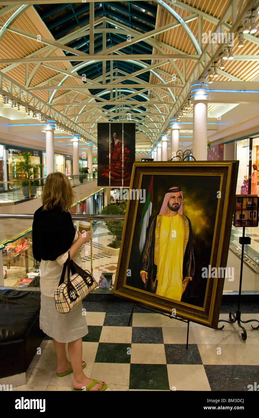 Westliche Frau vor Bild der Herrscher von Dubai Stockfoto