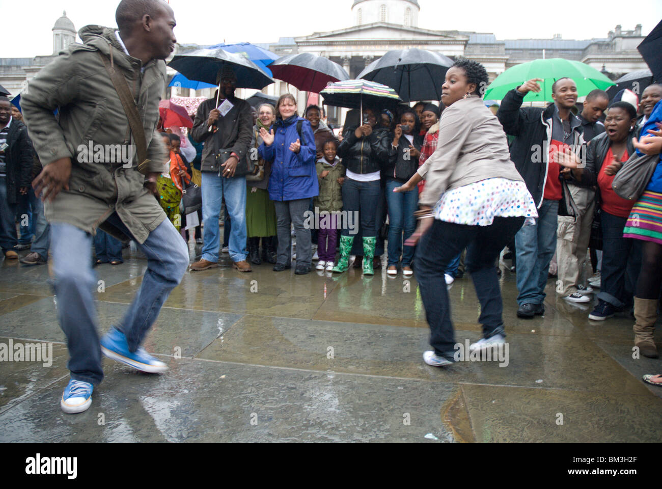 Tanzen im Regen am Festkonzert Afrikatag, Trafalgar Square, London, UK Stockfoto