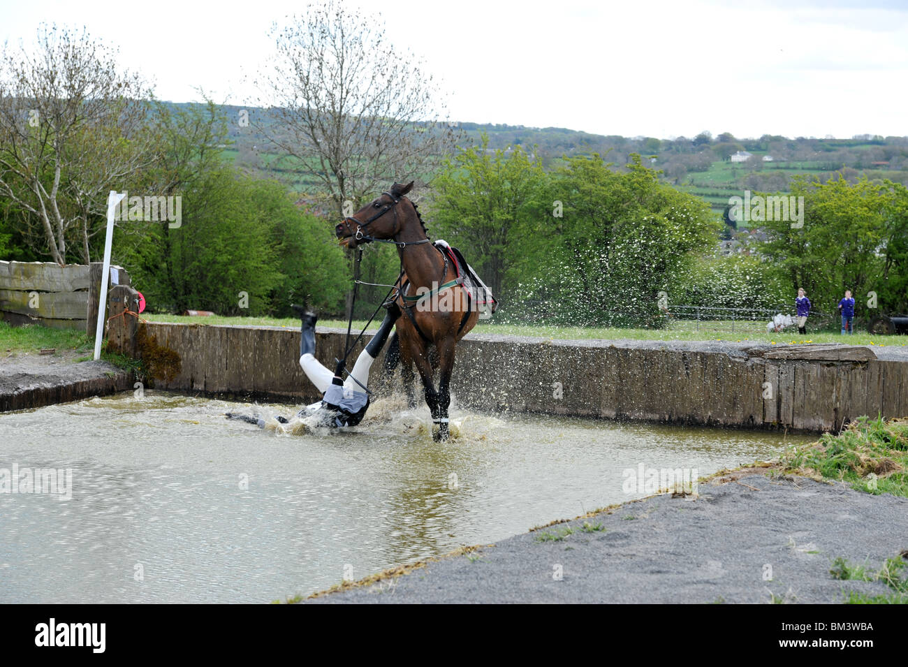 Reiter von einem Pferd ins Wasser fallen Stockfoto