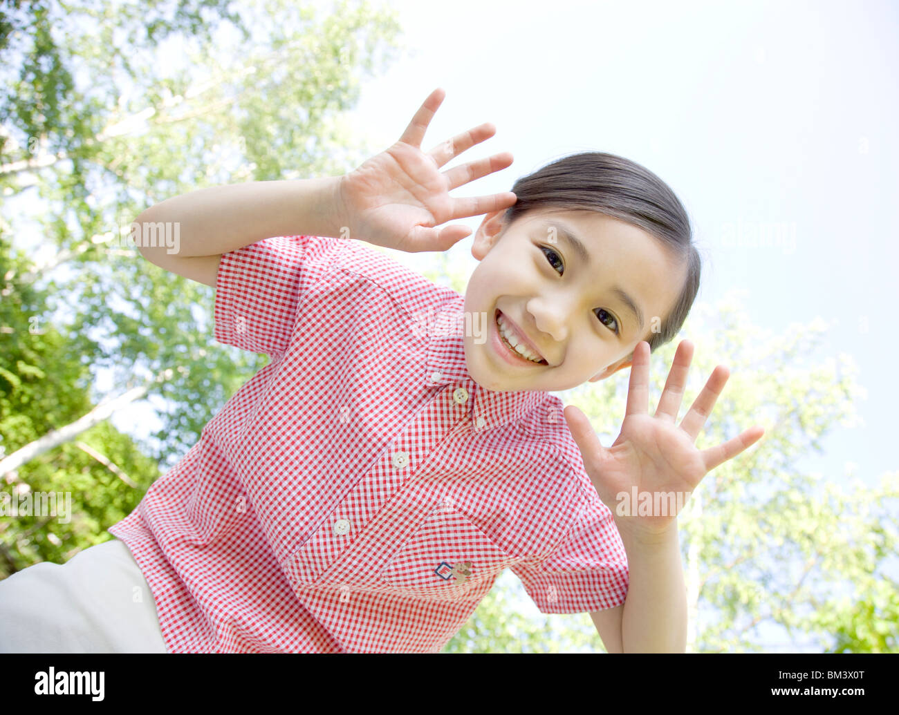 Portrait von stehendes Mädchen in Grün, Open Palms durch Gesicht Stockfoto