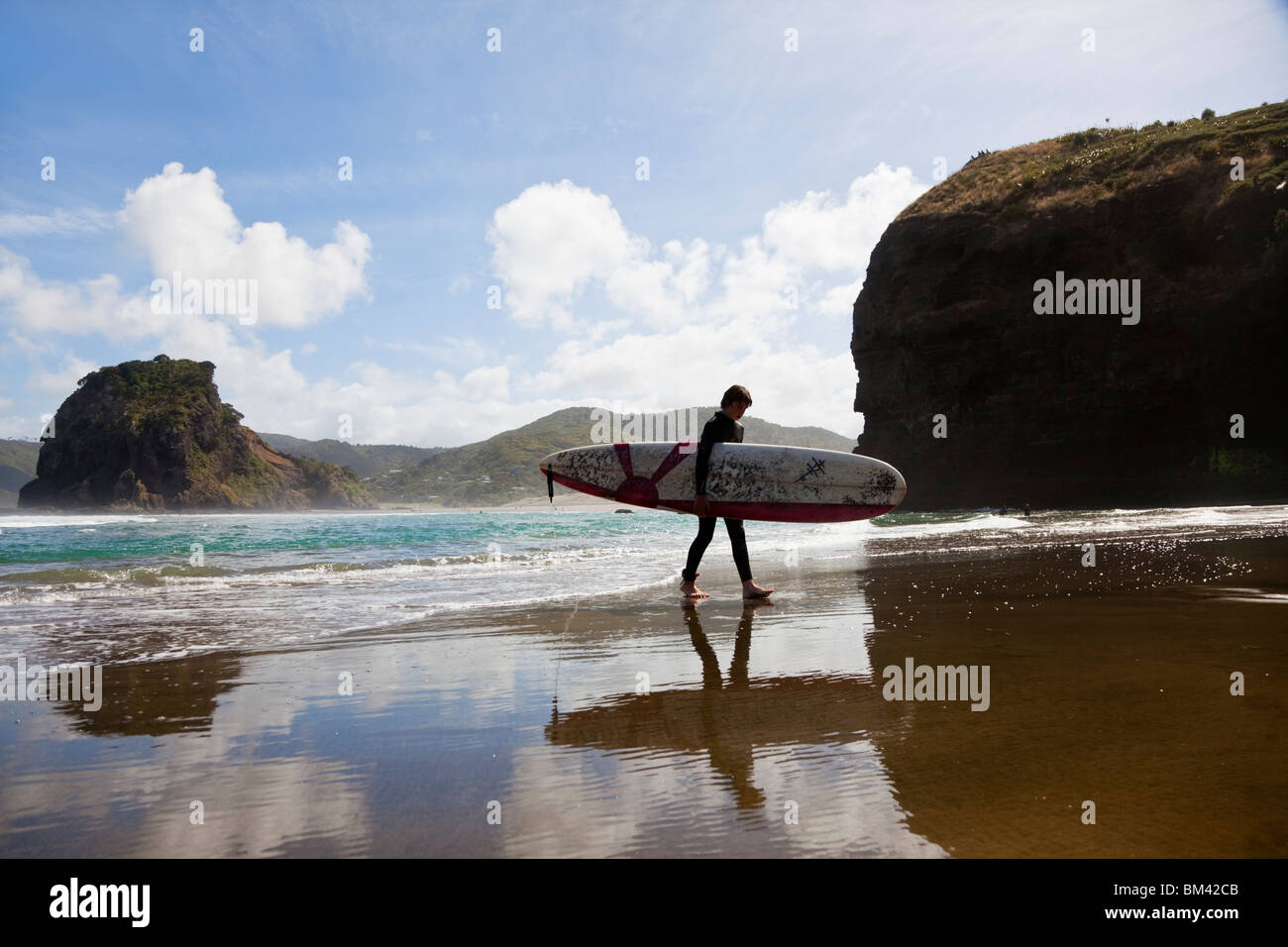 Surfer am Strand Piha. Piha, Waitakere Ranges Regional Park, Auckland, Nordinsel, Neuseeland Stockfoto