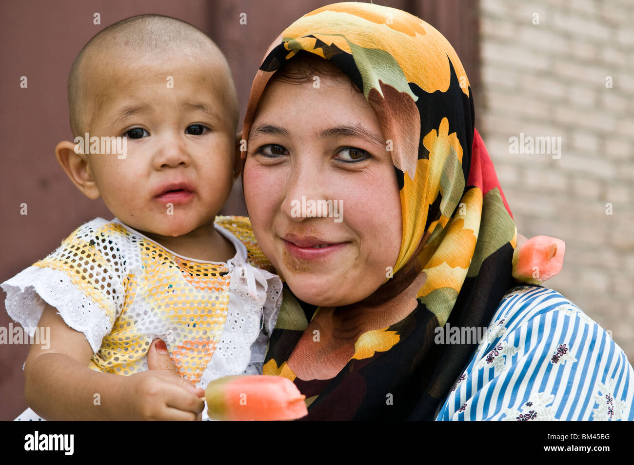 Eine uigurische Mutter mit ihrem Baby. Stockfoto