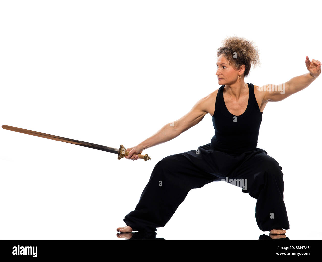 Reife Frau Taiji Tai Chi Chuan mit Schwert im Studio auf weißen Hintergrund isoliert Stockfoto