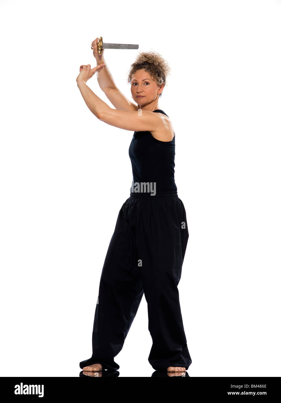 Reife Frau Taiji Tai Chi Chuan mit Schwert im Studio auf weißen Hintergrund isoliert Stockfoto