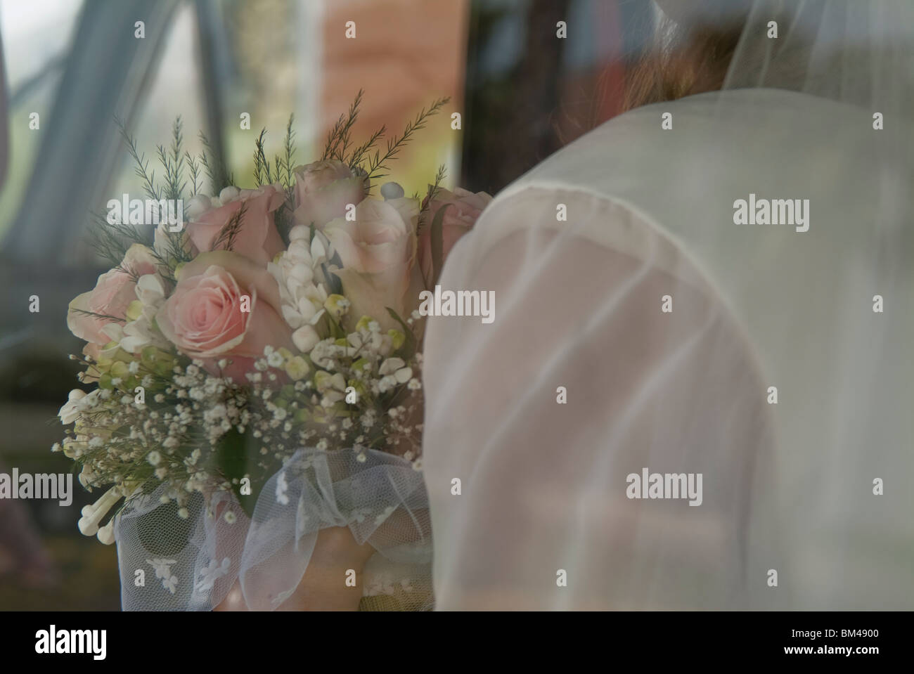 Braut mit Blumen Blumenstrauß sah durch Autofenster Stockfoto