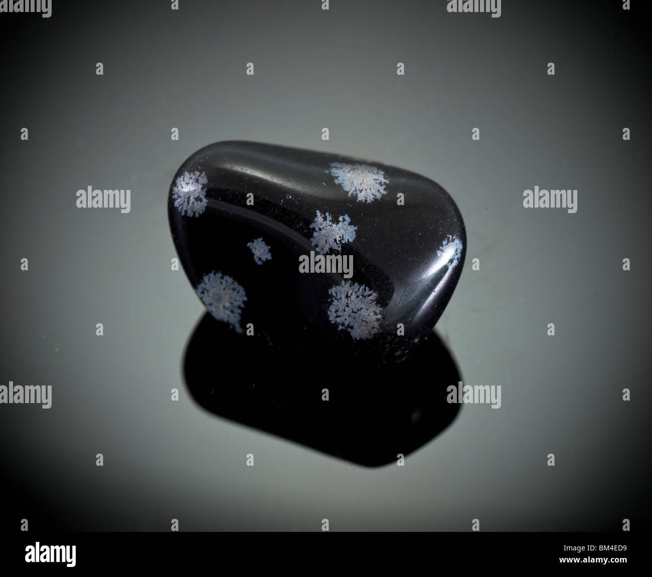 Ausschnitt aus einer Schneeflocke Obsidian Edelstein auf schwarzem Hintergrund Stockfoto