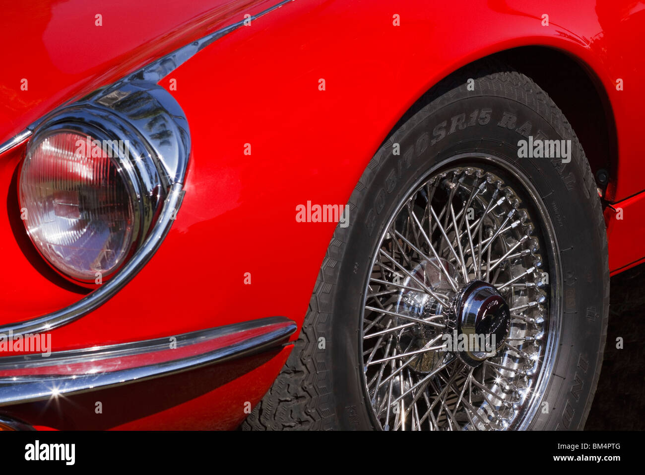 Nahaufnahme der Scheinwerfer und Rad des roten Jaguar E Typ. Stockfoto