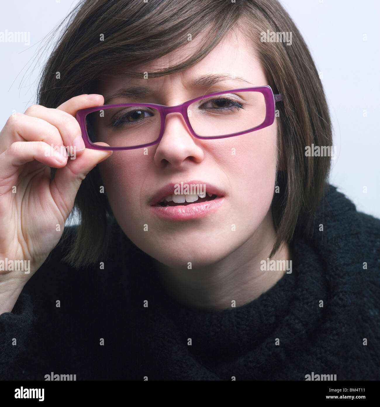 Junge Frau mit lila Brille und Sehschwäche / vision Stockfoto