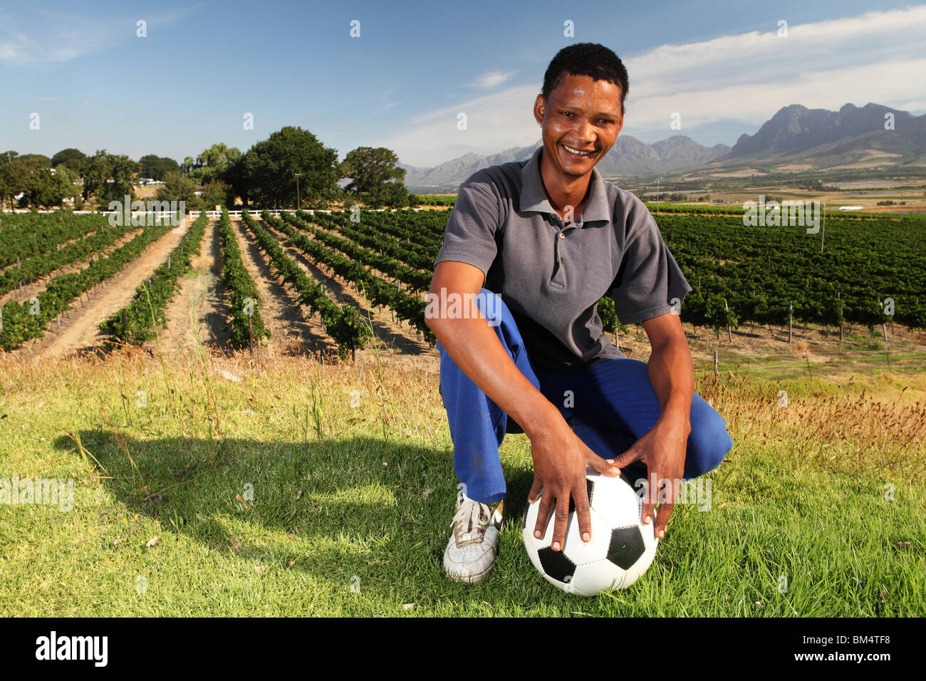 Ein junger Mann steht mit einem Fußball in der Weinherstellung Fläche von Paarl in Südafrika und warten auf die Fußball-Weltmeisterschaft Stockfoto