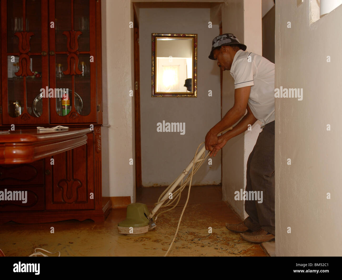 Mann mit einem Staubsauger in seinem Haus in der Gemeinde Stockfoto
