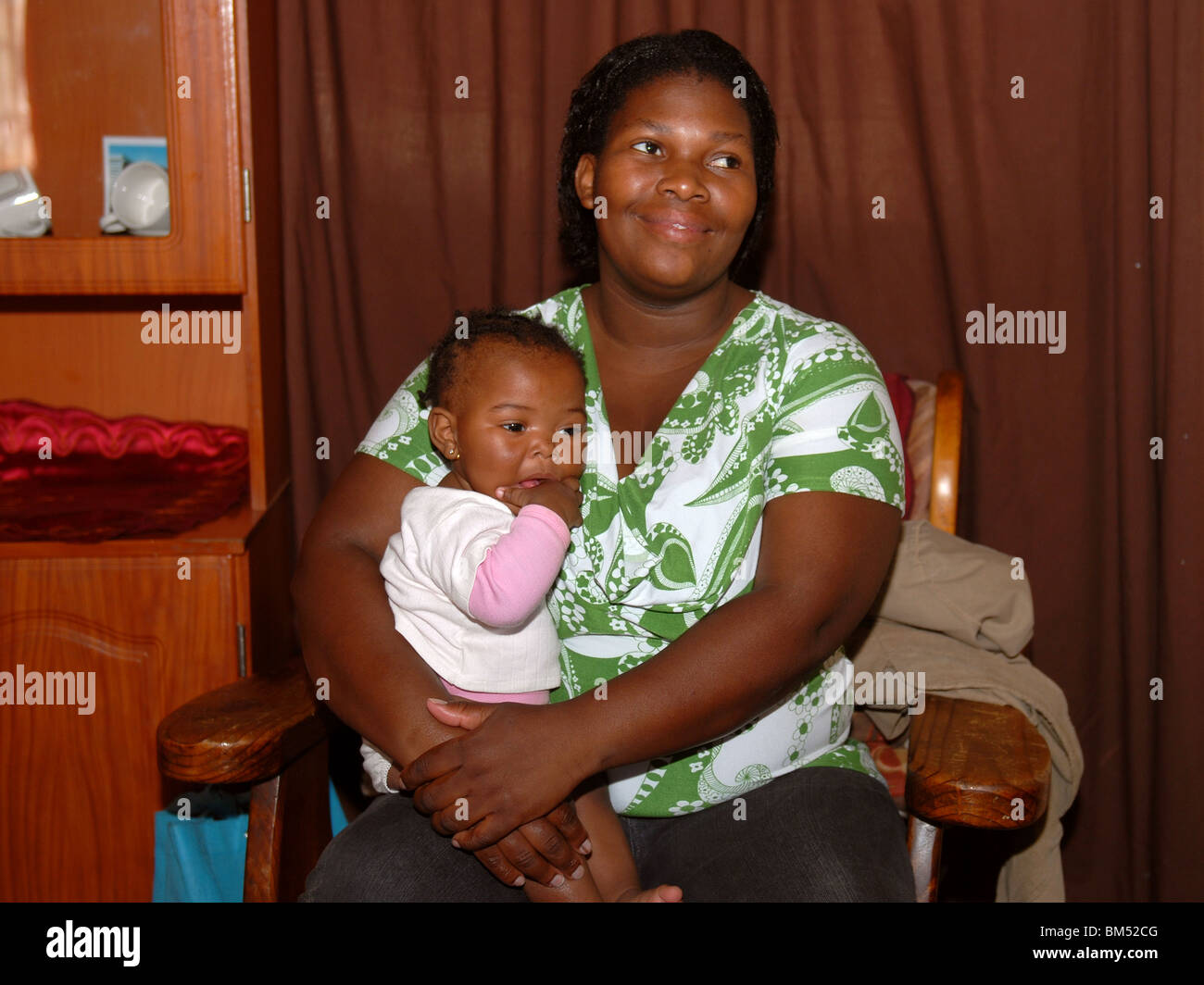 Eine Mutter mit ihrem Kind auf dem Arm in einer Baracke. Stockfoto
