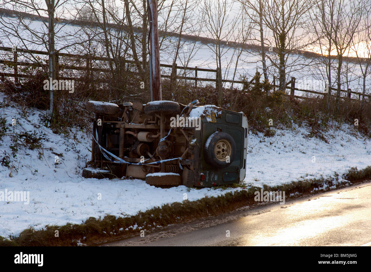 Einen umgestürzten Landrover neben einer schmalen Landstraße nach einem Unfall im Schnee und eisigen Bedingungen in Devon UK Stockfoto