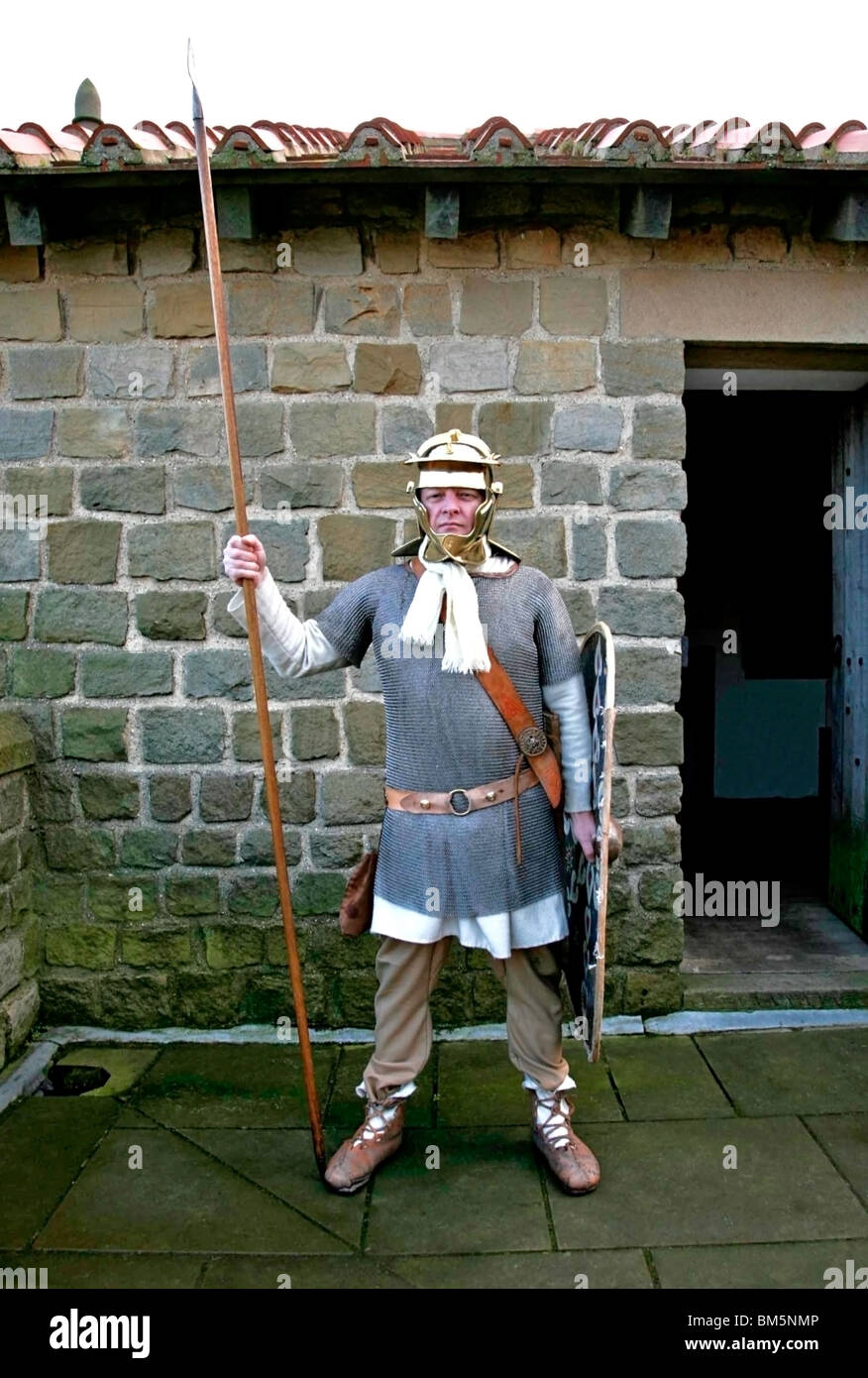 Römer Kostüm gekleidet Soldat auf Wache Position mit Speer und Schild, Helm und Rüstung Farbe Stockfoto