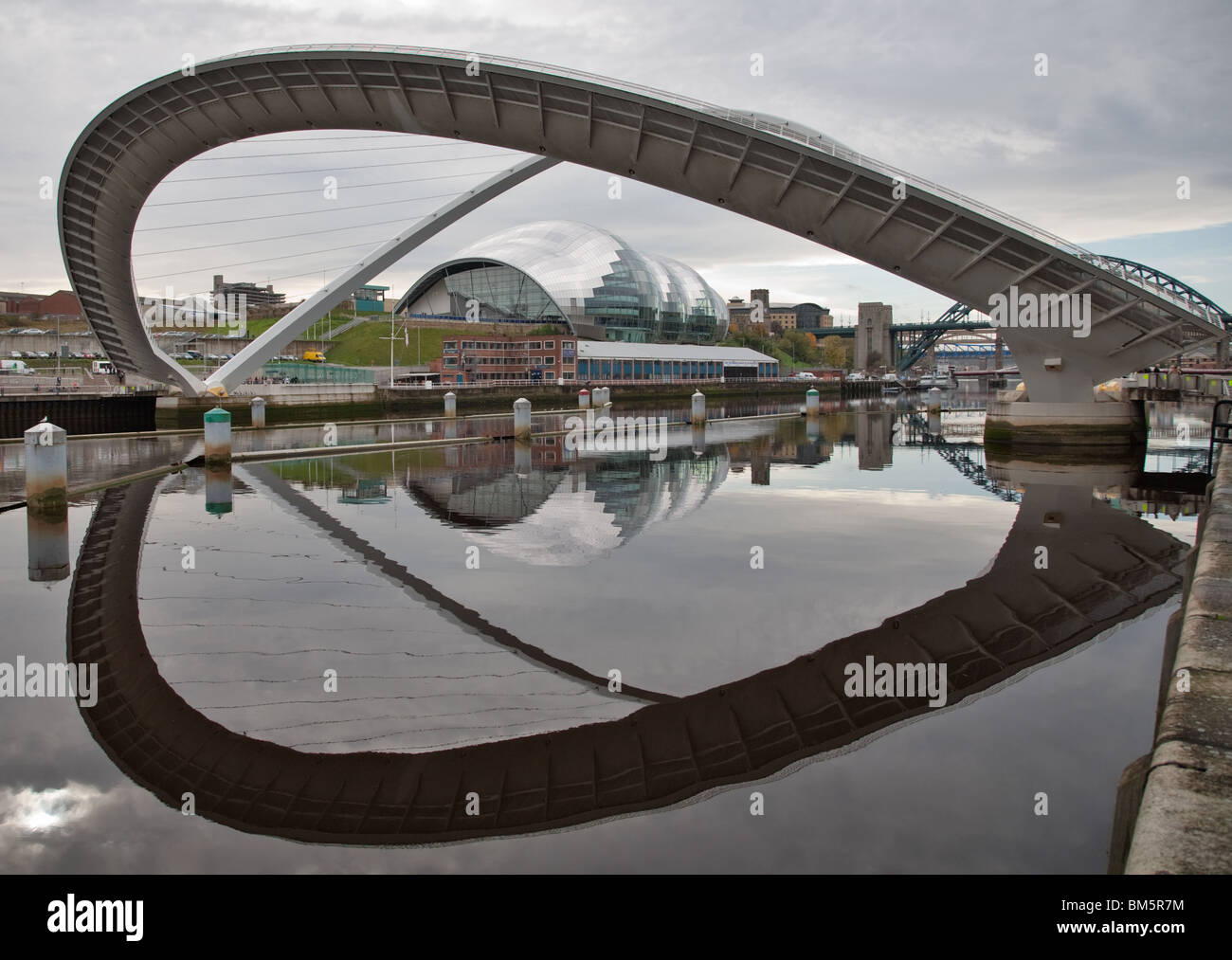 Millennium Bridge am Fluss Tyne Gateshead Winking Auge dem Erdboden gleichgemacht mit Spiegelbild im Fluss Tyne Salbei im Hintergrund Stockfoto