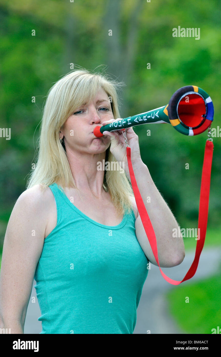 Weibliche südafrikanische Fußball-Anhänger eine Vuvuzela Horn bläst Stockfoto
