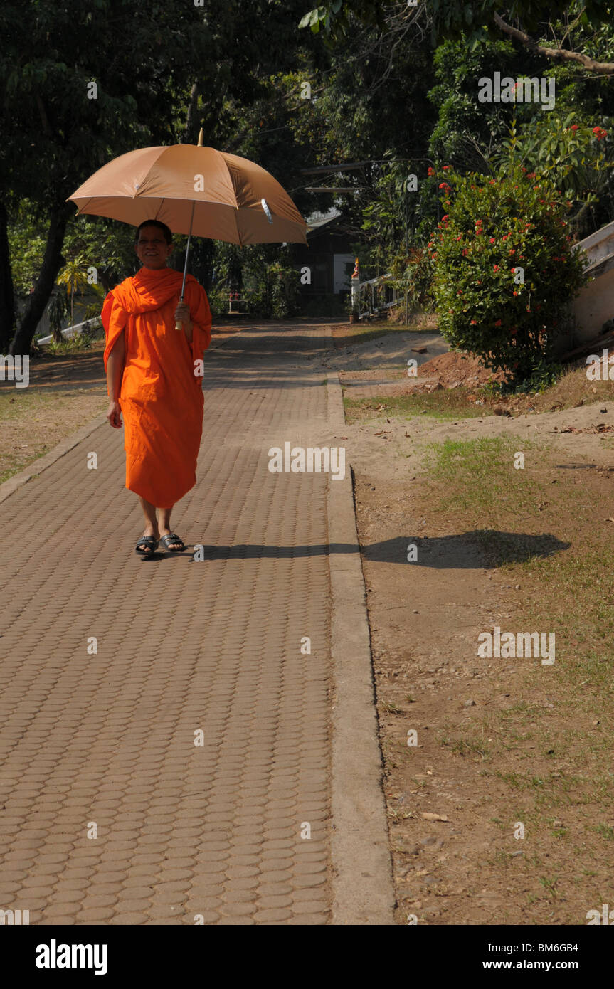 Mönch hält Regenschirm für den Schatten von Mittagssonne, Kam Ko Tempel Wat, Mae Hong Son, thailand Stockfoto