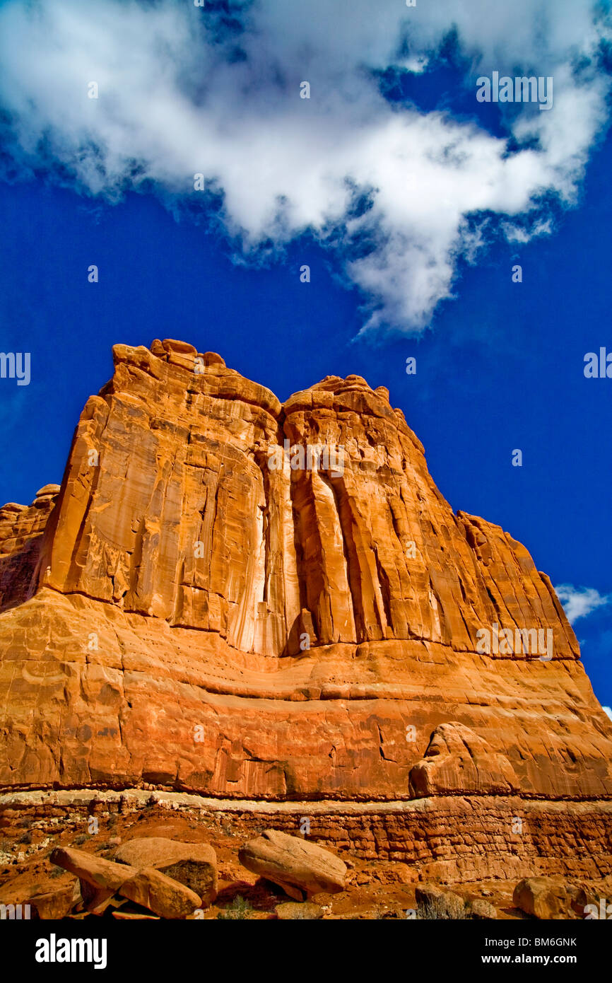 Die Entrada Sandsteinwände der Courthouse Towers im Arches-Nationalpark, Utah, sind Wolken und blauer Himmel gegenübergestellt. Stockfoto