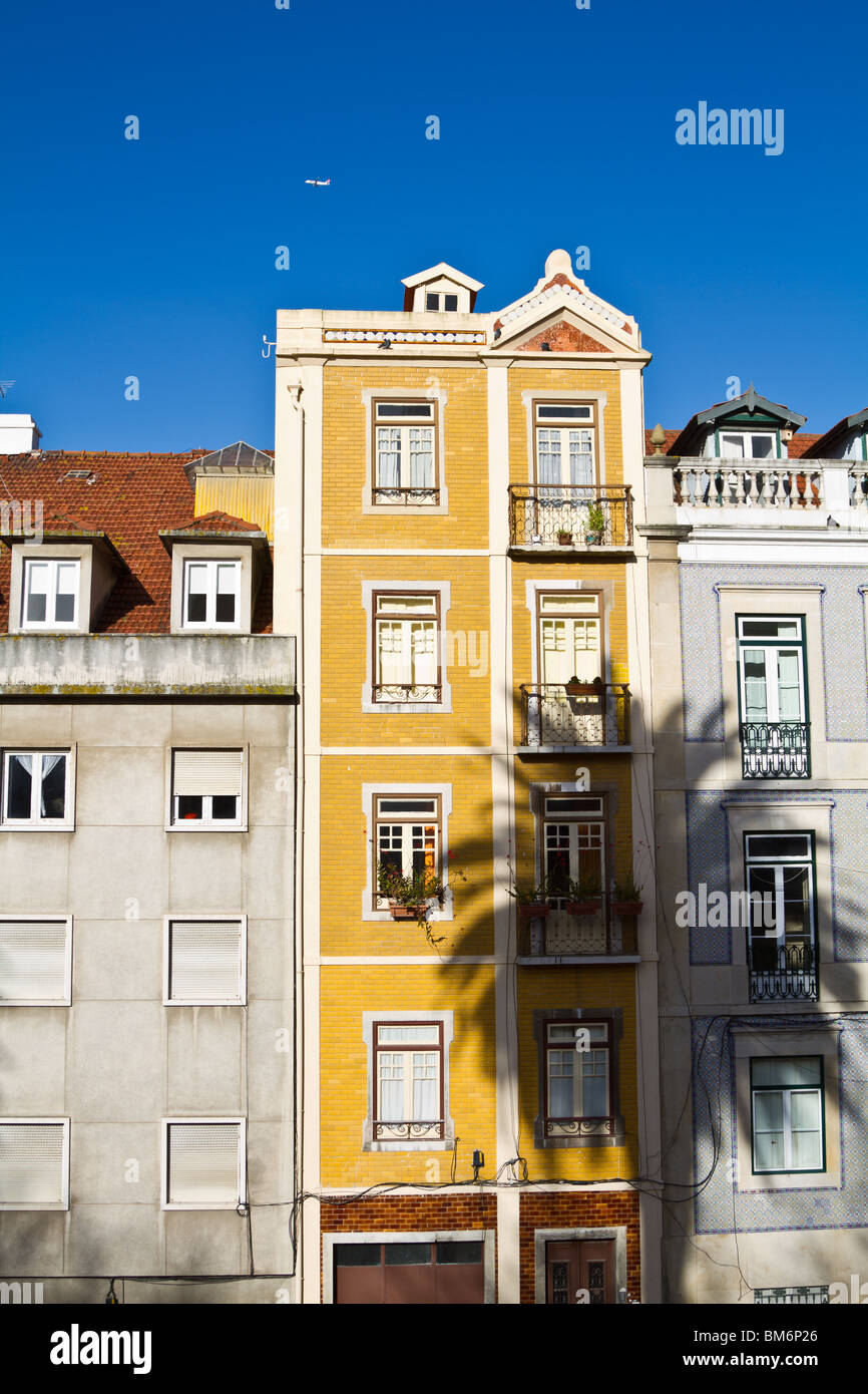 Konzentrieren Sie sich auf ein 4-stöckiges bunten traditionellen Wohnhaus mit Schatten einer Palme. Lissabon, Portugal Stockfoto