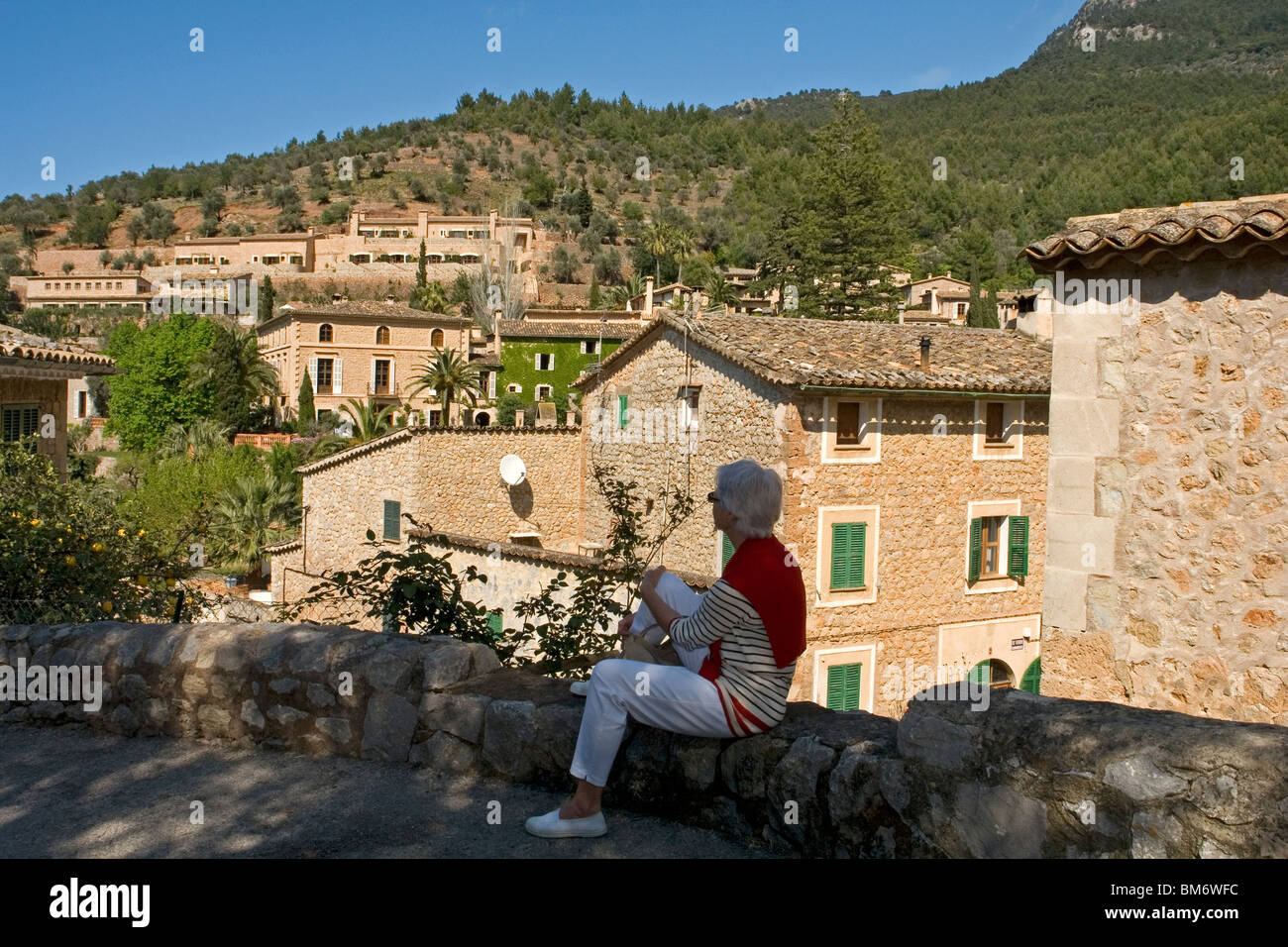Eine Dame touristischen Blick auf einige schöne Häuser in Deià (Mallorca - Spanien). Une Hauptbusstation Contemplant Certaines Maisons de Deia. Stockfoto